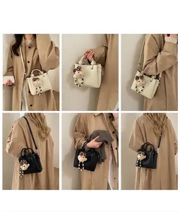 Detail showing minimalist bucket bag with knot handle and polka dot bear charm accessory