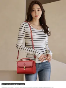 Minimalist red leather baguette bag with top handle and gold clasp for women