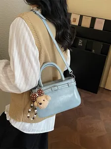 Minimalist light blue bucket bag with leather texture and cute plush bear charm