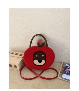 Detail of red apple-shaped bag featuring cute Shiba Inu towel embroidery and green leaf