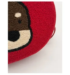 Detail of red plush fabric with cartoon bear embroidery on small crossbody bag