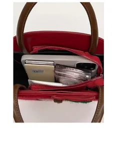 Top view of red leather crossbody bag interior showing daily storage capacity and pocket