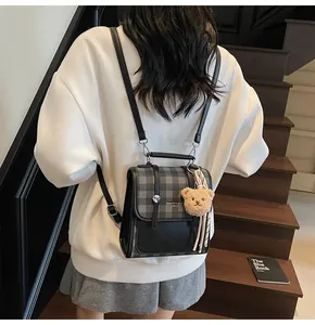 Detailed back view of vintage plaid mini backpack with cute brown plush bear charm