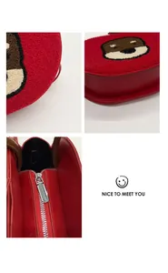 Detail view of red bear crossbody bag featuring plush texture and secure metal zipper
