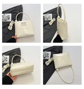 Dettagli di una borsa in pelle color crema con perla decorativa e dettaglio a nodo