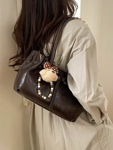 Dark brown faux leather tote bag with lychee texture and cute bear charm accessory