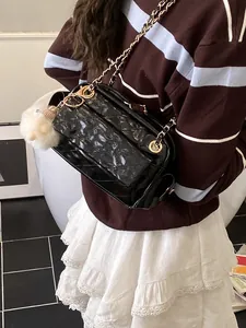 Bolso baguette acolchado negro con cadena dorada y colgante pompon blanco