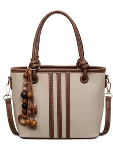 Chic beige bucket bag with brown leather trim, knotted handle and wooden bead charm