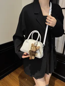 Minimalistische weiße Baguette-Tasche mit verstellbarem Riemen und Bären-Anhänger