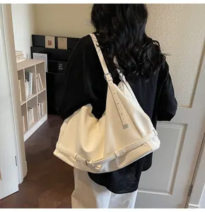 Detailed view of white large-capacity tote bag showing soft texture and strap buckle