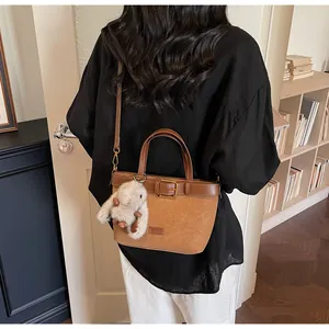 Détail du sac seau en cuir PU marron avec boucle décorative et charm de lapin en peluche
