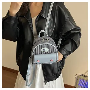 Détail du mini sac à dos à rayures bleues avec patch cartoon et rabat en cuir bleu