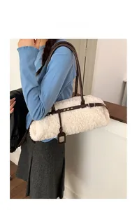 Detail of white sherpa tote bag with dark brown leather straps and buckle on model