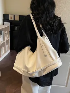 Large cream white slouchy leather tote bag with adjustable buckle straps shown on shoulder