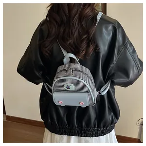 Vue arrière d'un mini sac à dos en toile rayée avec cuir bleu clair sur une veste