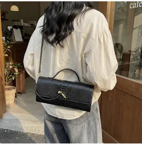 Detail der schwarzen Baguette-Tasche aus geprägtem Leder mit goldener Hardware