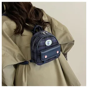 Rear view of a mini plaid backpack featuring a cute bear patch on a khaki coat