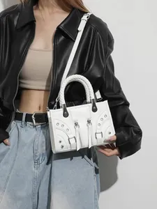 White faux leather crossbody bag with woven handle and silver studs in motorcycle style