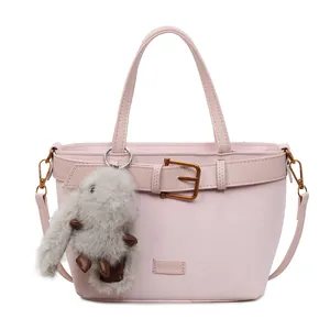 Dettaglio borsa in camoscio rosa con fibbia in metallo retrò e ciondolo a coniglio grigio