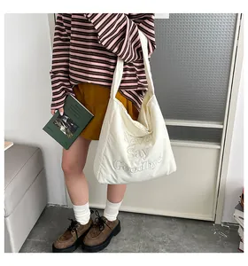 Détail du sac cabas en toile blanche avec broderie pour un look décontracté quotidien