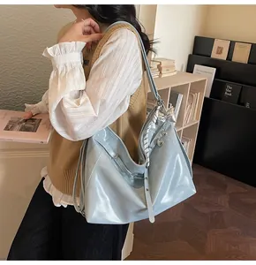 Close-up of light blue patent leather tote bag with silver bow and heart charm details