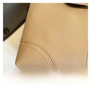 Detail of high-quality beige leather material with precise double-stitching on tote bag