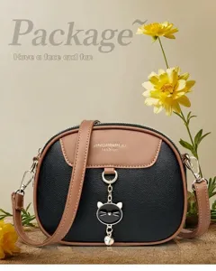 Detail van elegante tweekleurige kunstlederen crossbodytas met gouden hardware en hanger