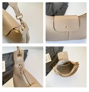 Detail view of cream tote bag features metal zippers, magnetic closure and inner pocket