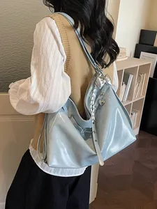 Light blue faux leather hobo tote bag with bow charm and ribbon details