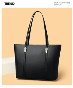 Détail d'un sac cabas en cuir noir grainé avec des boucles métalliques dorées élégantes