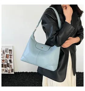 Close-up of a light blue hobo bag with a classic metal buckle shown on a model