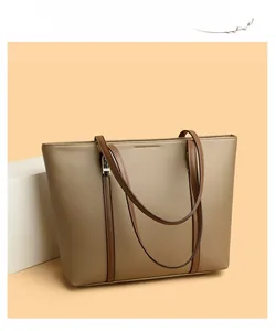 Gros plan sur le sac fourre-tout en cuir marron avec texture grainée et détails de sangles