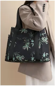 Detail of leaf print tote bag with side pockets and durable black woven handles