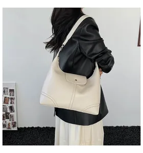 Model wearing a minimalist cream-colored large capacity shoulder bag with wide strap