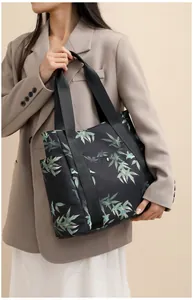 Detailed view of large tote bag featuring artistic bamboo leaf prints and wide woven handles
