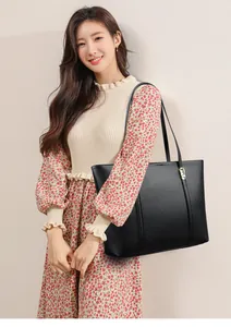 Détail du grand sac cabas noir en cuir à motif litchi avec ferrures dorées