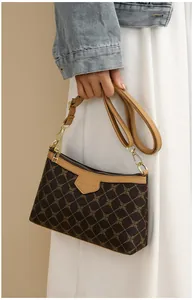 Detail of vintage brown shoulder bag with golden chain pattern and chic metal hardware
