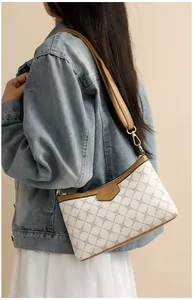 Detail of printed crossbody bag with vintage chain pattern and leather shoulder strap
