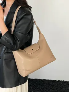 Minimalist beige leather tote bag with flap closure and elegant metal buckle detail
