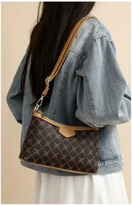 Close-up of vintage brown chain pattern shoulder bag with leather trim on model