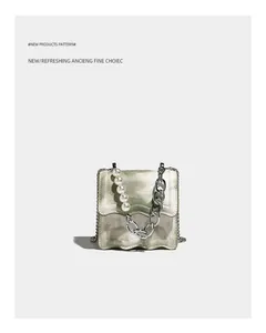 Dettaglio mini borsa a tracolla marmo verde con manico di perle e catena argento