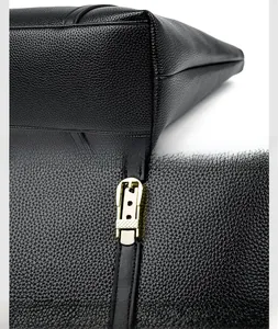 Gros plan sur les coutures du sac en cuir noir et les détails des ferrures dorées