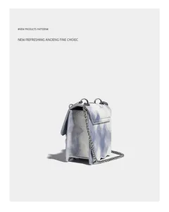 Dettaglio borsa a tracolla con motivo marmorizzato blu e bianco, base ondulata e catena