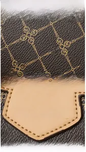 Detail of brown litchi pattern PU leather with golden logo and neat stitching