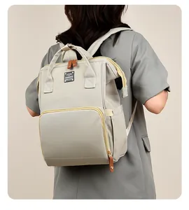 Bolso cambiador multifuncional gris claro de tela resistente con tiradores de piel marrón