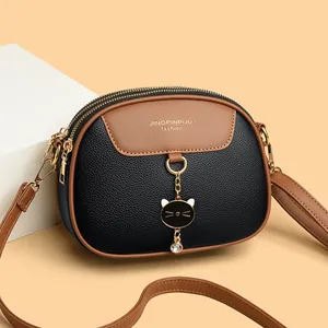 Tweekleurige zwart-bruine crossbodytas met litchi-patroon en metalen tashanger