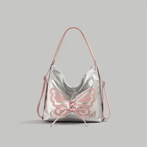 Detail of silver metallic tote with pink butterfly applique and ribbon lace-up design
