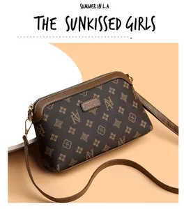Close-up of vintage brown crossbody bag with monogram pattern and gold metal hardware