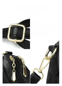 Detail showing polished gold-tone metal hardware and lychee pattern black leather texture