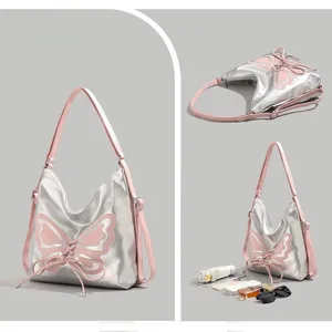 Detail of silver hobo bag with pink butterfly patch, lace-up design, and spacious interior
